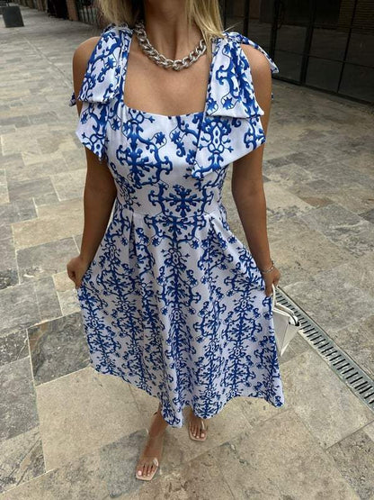 Blue patterned poplin dress with bows on shoulders